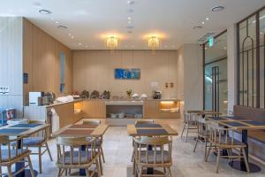 a restaurant with wooden tables and a kitchen at Daegu Hyeonpung Prana Hotel in Daegu