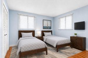 two beds in a room with blue walls and windows at MOUNTAIN WILLOW GETAWAY in Jackson