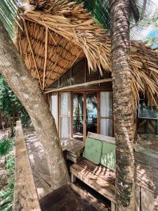 a building with a bench and a straw roof at BOA BOA Bacalar in Bacalar