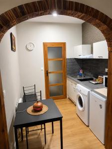 a kitchen with a table and a washer and dryer at Studio Magnifique in Darnétal