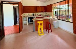 a kitchen with a counter and a yellow stool at Chalet Natalia Montenegro Quindío in Montenegro