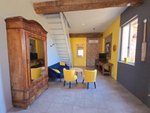 a living room with a table and yellow chairs at La parenthèse de Saint Esselin 2 in Larreule