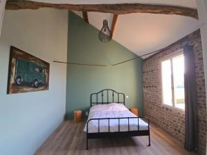 a bedroom with a bed and a brick wall at La parenthèse de Saint Esselin 2 in Larreule