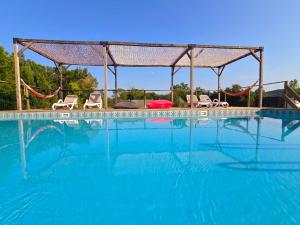 a large swimming pool with chairs and a gazebo at La parenthèse de Saint Esselin 2 in Larreule