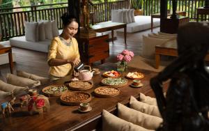 a woman standing in front of a table full of food at The Community - Siem Reap in Siem Reap