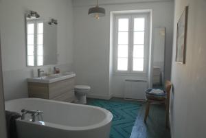 a bathroom with a tub and a sink and a toilet at la colombe du marais in Courçon