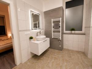 a white bathroom with a sink and a mirror at Vacation Room in Traben-Trarbach