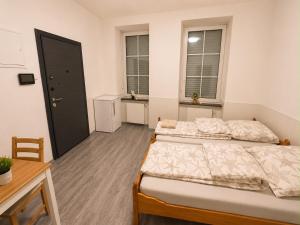 a bedroom with two beds and a table and two windows at Vacation Room in Traben-Trarbach