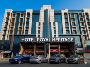 a hotel royal heritage with cars parked in front of it at Hotel Royal Heritage in Gandhinagar