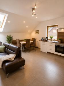 a living room with a leather couch and a table at Ferienwohnung Biohof Untermar in Obervellach
