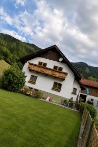 a large white house with a grass yard at Ferienwohnung Biohof Untermar in Obervellach