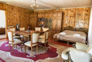 a dining room with a table and a bed at Guest House Nino in Mestia