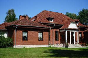 a large brick house with a red roof at Thula - Apartment in Villa Ambrosian in Trzebież