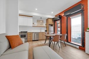 a kitchen and living room with a couch and a table at Lofts Orizon in Rimouski