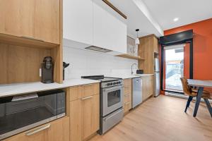 a kitchen with wooden cabinets and a stove top oven at Lofts Orizon in Rimouski