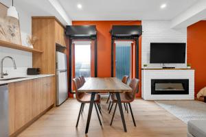 a kitchen with a table and chairs and a tv at Lofts Orizon in Rimouski