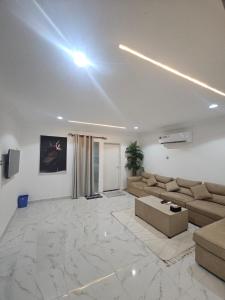 a living room with a couch and a table at Bedroom Jimi in Al Ain