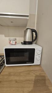 a microwave with a tea kettle on top of it at Mare Apartment in Nocera Inferiore