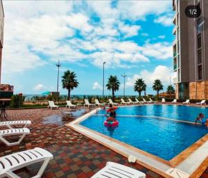 a pool at a hotel with people playing in it at Студия у чистейшего Моря! in Gonio