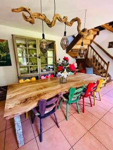 a large wooden table in a kitchen with colorful chairs at Maison de gesves in Gesves +22 photos