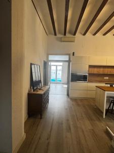 an empty room with a kitchen with a wooden floor at Casa Capereta in Alberique