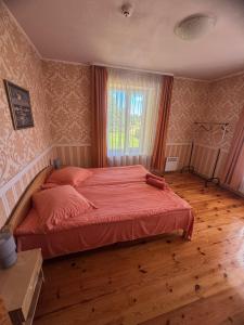 a bedroom with a large bed with red sheets and a window at Leču muiža in Lēči +27 photos