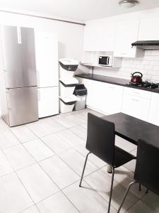 eine Küche mit einem Kühlschrank sowie einem Tisch und Stühlen in der Unterkunft KWATERY KALINA-DUSZKA HOSTEL in Płock