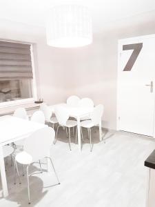 a white dining room with white tables and white chairs at KWATERY KALINA-DUSZKA HOSTEL in Płock