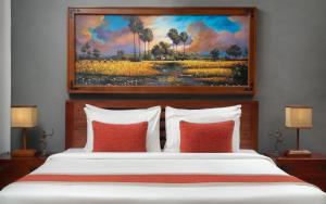 a bedroom with a bed with a painting on the wall at The Community - Siem Reap in Siem Reap +57 photos
