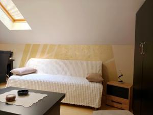 a small bedroom with a bed and a table at Nebeski kutak in Valjevo
