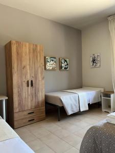 a bedroom with two beds and a wooden cabinet at B&B La Tenuta in Fermo