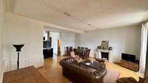 a living room with a leather couch and a fireplace at hotel de Croix in Morlaix