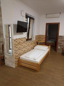 a bedroom with a bed and a flat screen tv at Euro Apartman in Debrecen