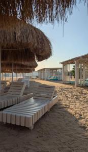 a row of chaise lounges and umbrellas on the beach at منتجع البرنسيسة ريزورت الغردقه in Hurghada