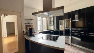 a kitchen with black cabinets and a white counter top at hotel de Croix in Morlaix