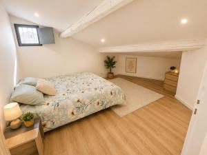 a bedroom with a large bed and a wooden floor at Elégant Duplex in Béziers