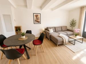 a living room with a couch and a table and chairs at Elégant Duplex in Béziers +12 photos
