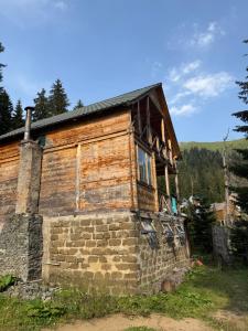 an old log house on a hill at BBR House in Chʼkhakoura