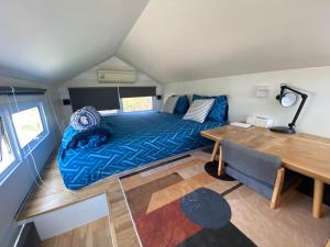 a small bedroom with a blue bed and a desk at Beachfront Tiny House, Koh Samui, Thailand with FREE Rowboat in Nathon Bay