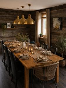 a wooden table with chairs and plates and candles at Chalet Le Quartz in Val Thorens