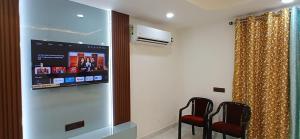 a room with two chairs and a flat screen tv at Dev Palace in Saharsa