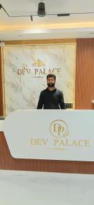 a man is standing in front of a mirror at Dev Palace in Saharsa