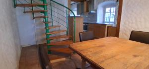 a kitchen with a wooden table and a spiral staircase at Milchhäusle in Söllingen