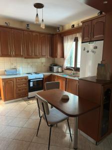 a kitchen with a table and a white refrigerator at Villa Malila in Panagia