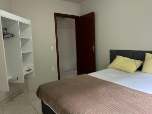 a bedroom with a bed and a closet at Aluguel casa Bombinhas in Bombinhas