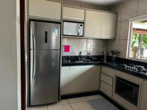 a kitchen with a stainless steel refrigerator at Aluguel casa Bombinhas in Bombinhas +5 photos