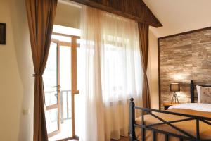 a bedroom with a bed and a large window at Dilijan Tun Boutique Hotel in Dilijan