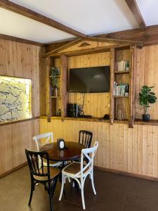 a dining room with a table and chairs and a tv at Dilijan Tun Boutique Hotel in Dilijan