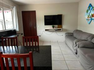 a living room with a couch and a table at Aluguel casa Bombinhas in Bombinhas