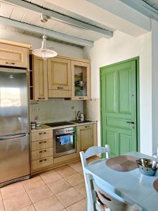a kitchen with a table and a green door at KLIMA apartment in Perdika